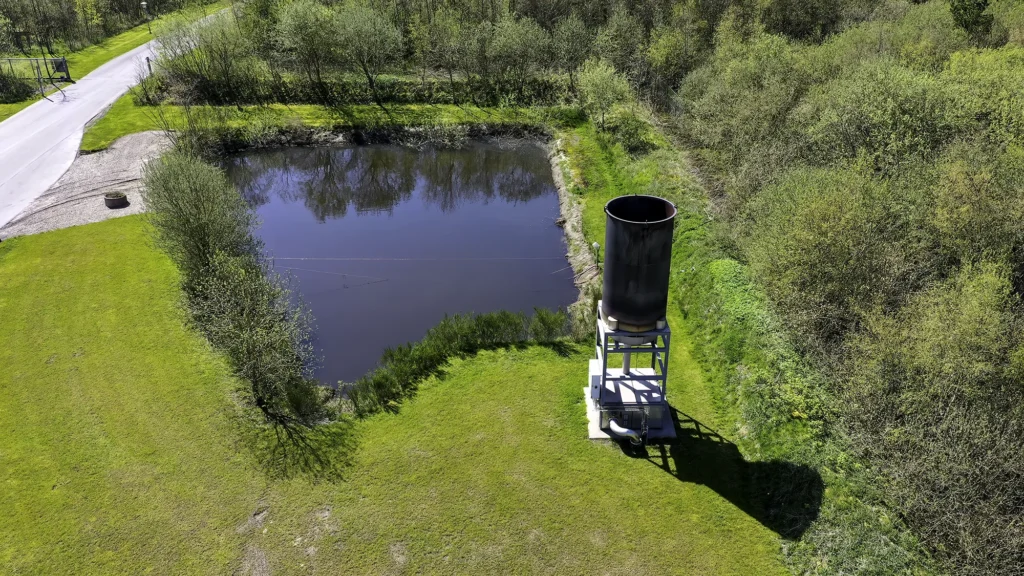 Lugtmåler ved Limfjordens Bioenergi-anlæg ved siden af regnvandsbassin i grønne omgivelser